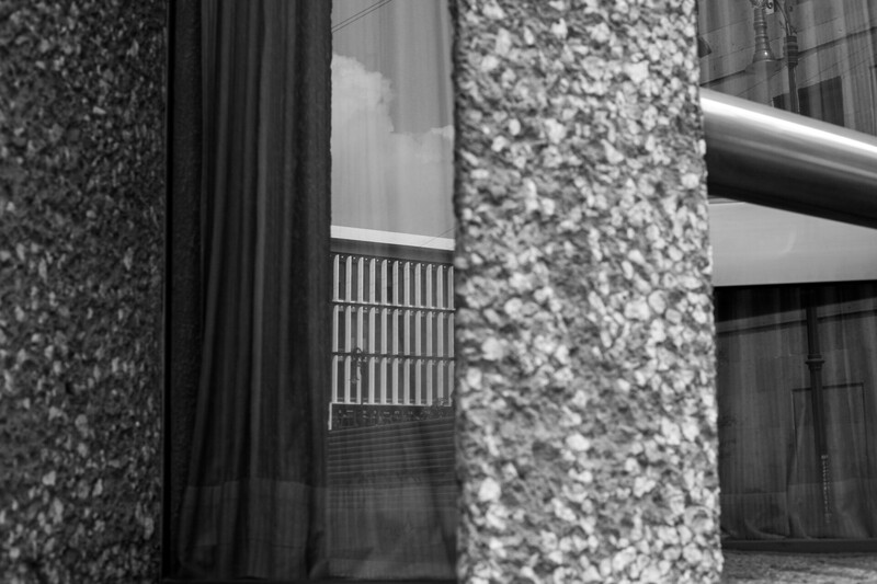 Black and white architectural photograph of brutalist concrete columns with textured aggregate surfaces