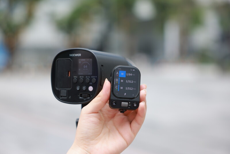 Hand holding wireless flash trigger and receiver units side by side