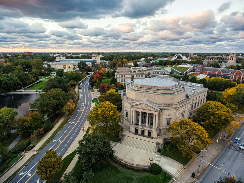 Aerial view of a classical domed building surrounded by autumn trees and urban landscape