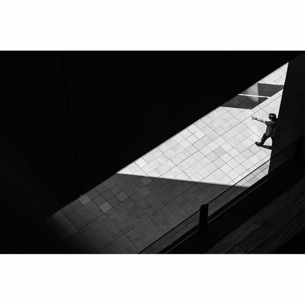 Minimalist architectural photography showing dramatic light and shadow across a geometric tiled surface