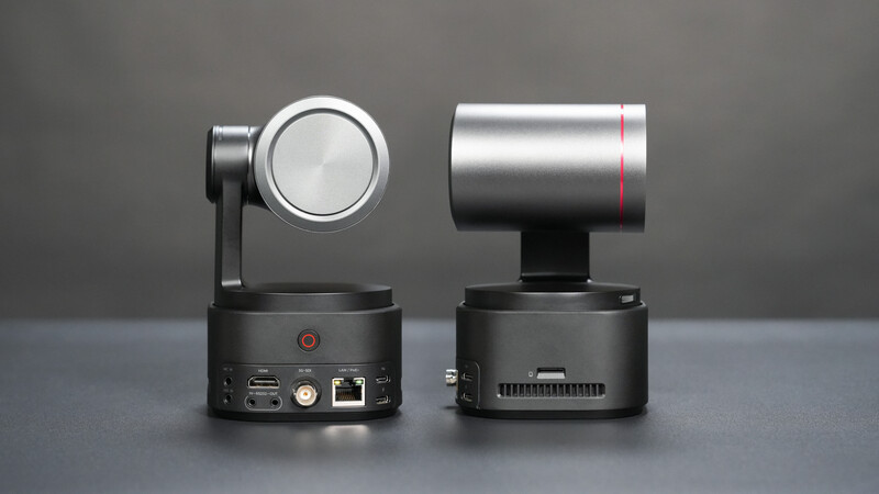 Two compact PTZ camera units shown from front and back, displaying pan-tilt-zoom heads and base stations with visible connectivity ports
