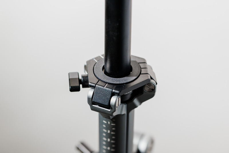 Close-up of a camera flash bracket or mounting clamp attached to a black pole