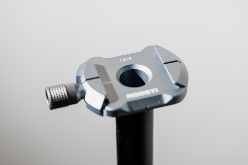 Close-up of a ball head tripod mount with silver aluminum construction and black center column
