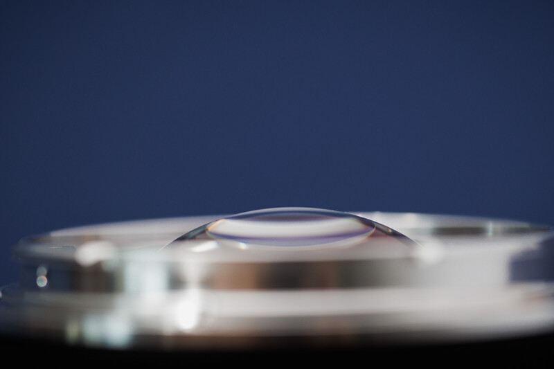 Close-up macro photograph of a camera lens element with shallow depth of field