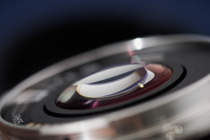 Close-up macro shot of camera lens elements showing internal glass optics and aperture blades