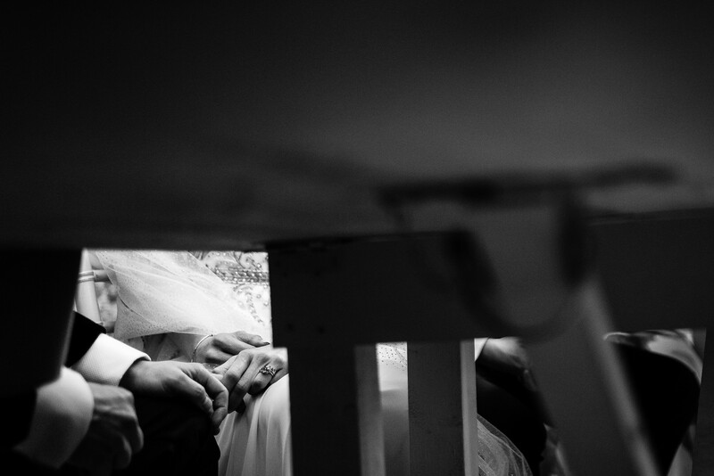 Newborn baby's hands grasping parent's finger in soft natural light, black and white portrait