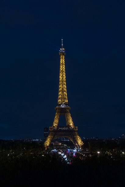 Eiffel Tower illuminated in warm golden light against a deep blue twilight sky