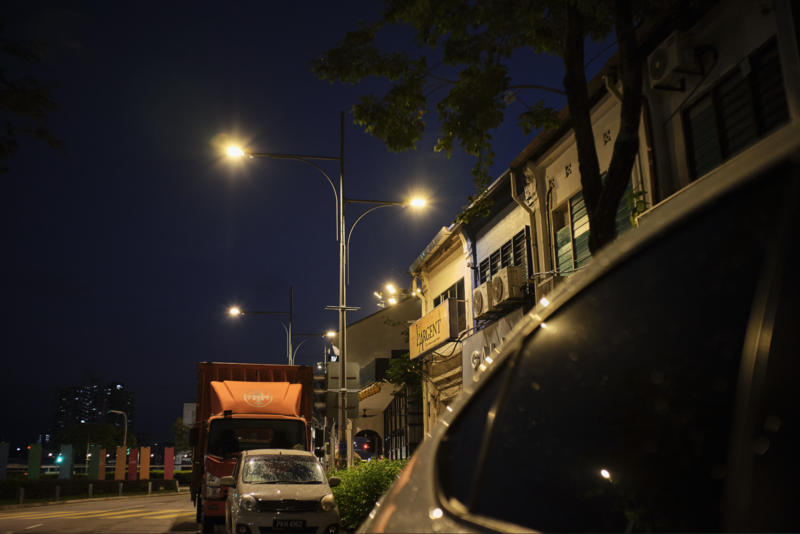 Night street scene with parked truck and warm street lighting illuminating buildings