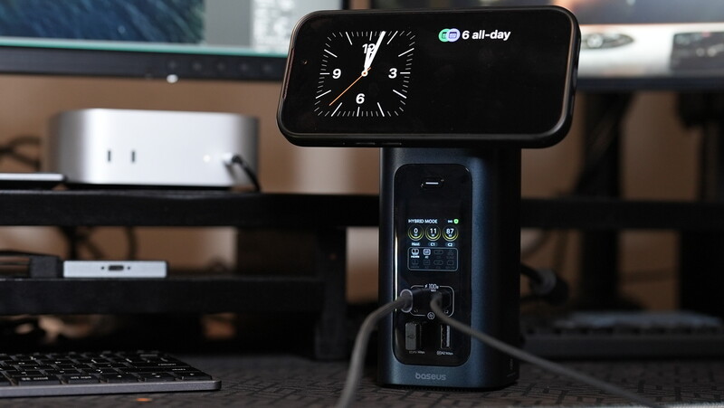 iPhone displaying clock widget on stand with control panel below, positioned on desk