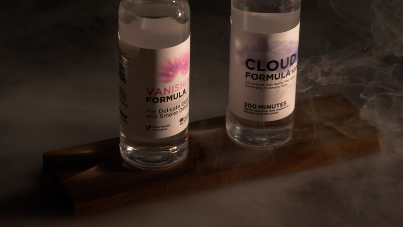 Two clear bottles labeled 'Cloud Formula' with dramatic dry ice fog effect on dark surface