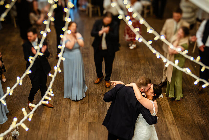 Bride and groom first dance at wedding reception with string lights overhead