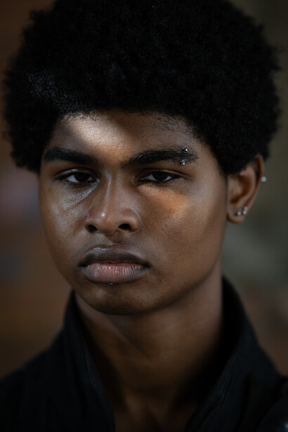 Portrait of a young man with direct gaze and neutral expression against blurred background