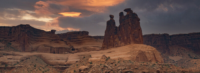 Towering sandstone rock formations at sunset in a desert landscape
