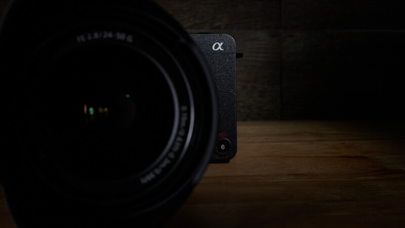 Sony Alpha mirrorless camera body with attached lens on wooden surface