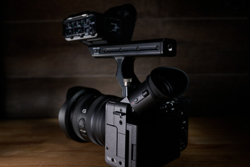 Sony FX30 cinema camera with external monitor and wireless microphone mounted on wooden surface