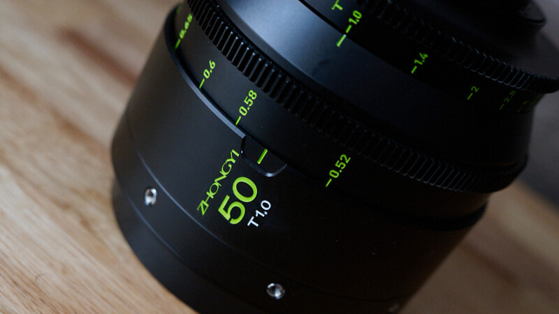 Zhongyi Mitacon 50mm f/1.0 lens with green text markings on wooden surface