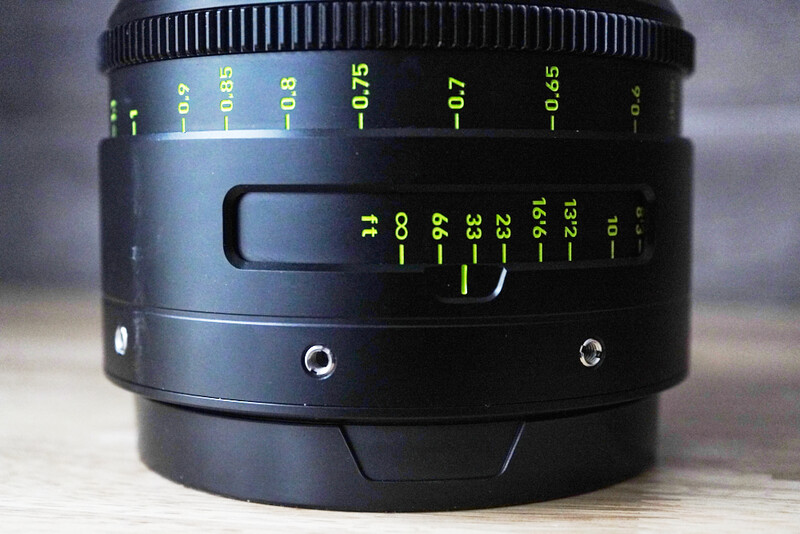 Black manual focus lens with distance scale markings and aperture ring visible