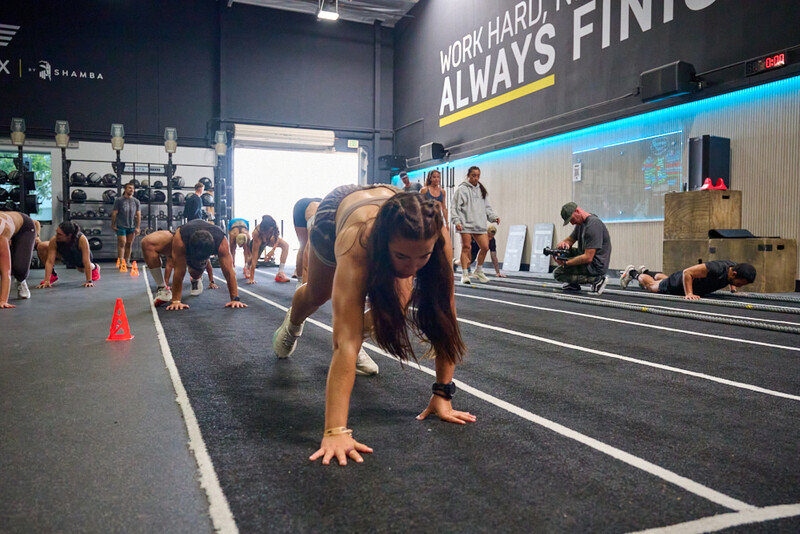 Athlete performing a plank exercise in a CrossFit gym during a group workout session