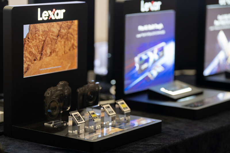 Lexar branded display booth featuring memory cards and product samples on black shelving