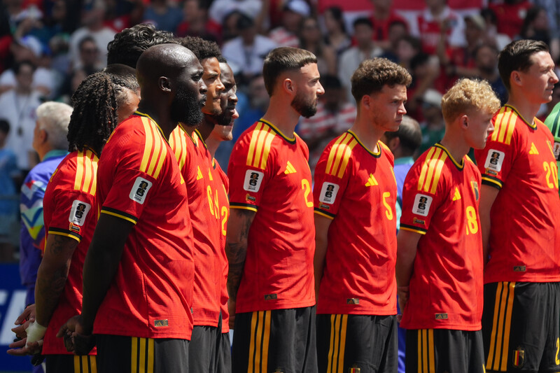 Soccer players in red and yellow uniforms standing in a line during a match