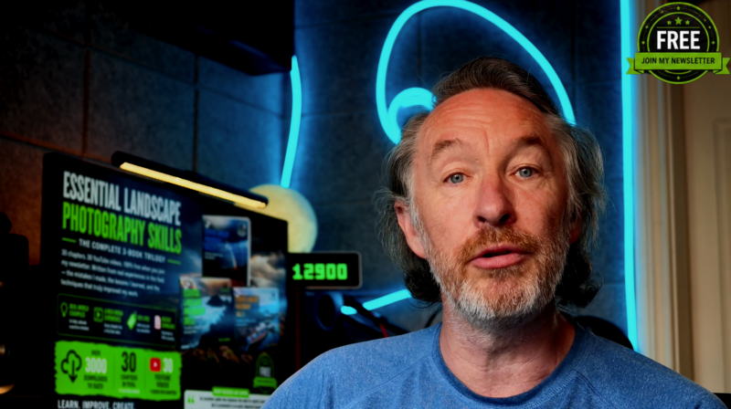 Male photographer speaking to camera with neon cyan headphone sign and green landscape photography course display behind him