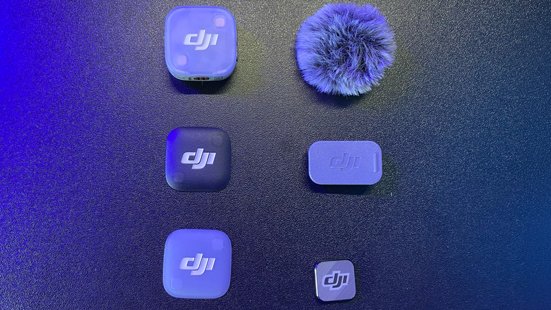 Six DJI microphone and audio products arranged on dark surface with blue lighting