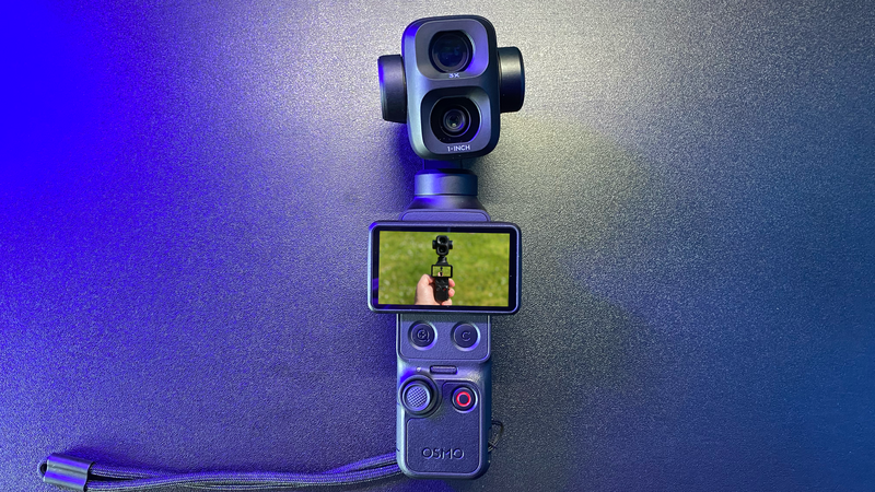 DJI Osmo Pocket 3 gimbal camera with flip-out display showing video preview against blue and purple gradient background