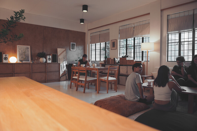 Interior cafe or studio space with warm wooden counter and communal seating area