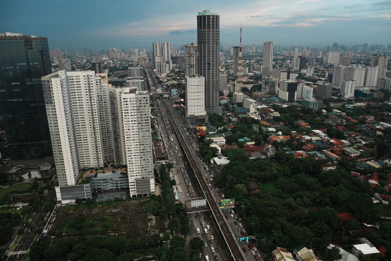 Aerial cityscape showing high-rise residential towers and urban sprawl at dusk