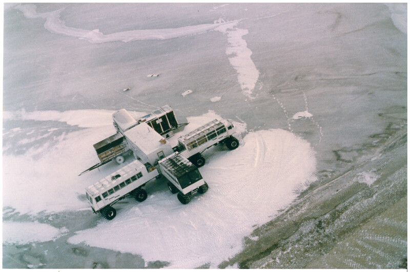 Aerial view of two fire trucks spraying water on dusty terrain