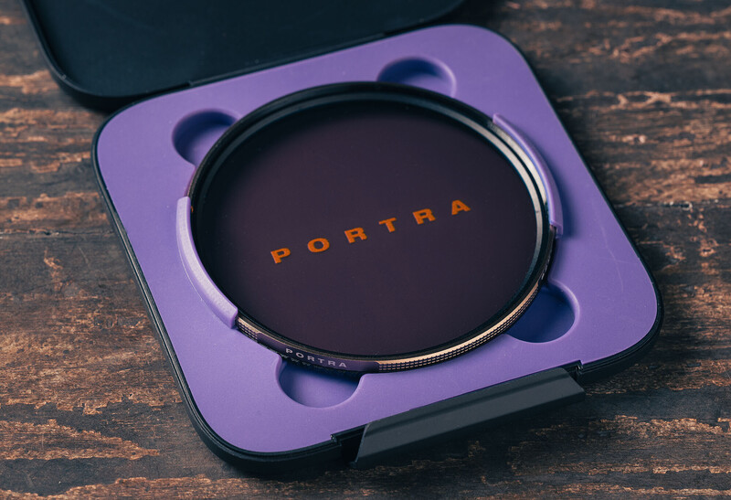 Portra filter in purple case on textured wooden surface