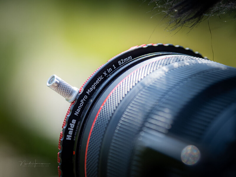 Macro photograph of camera lens barrel showing depth of field markings and focus ring