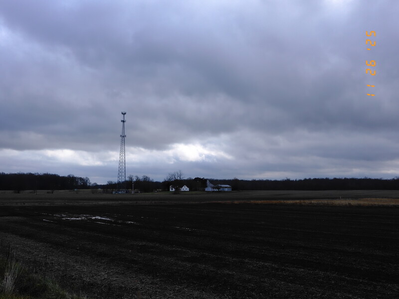 Rural landscape with communications tower under dramatic cloudy sky
