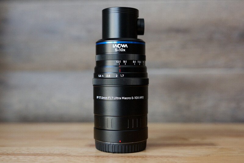 Laowa 100mm f/2.8 Ultra Macro lens mounted on wooden surface