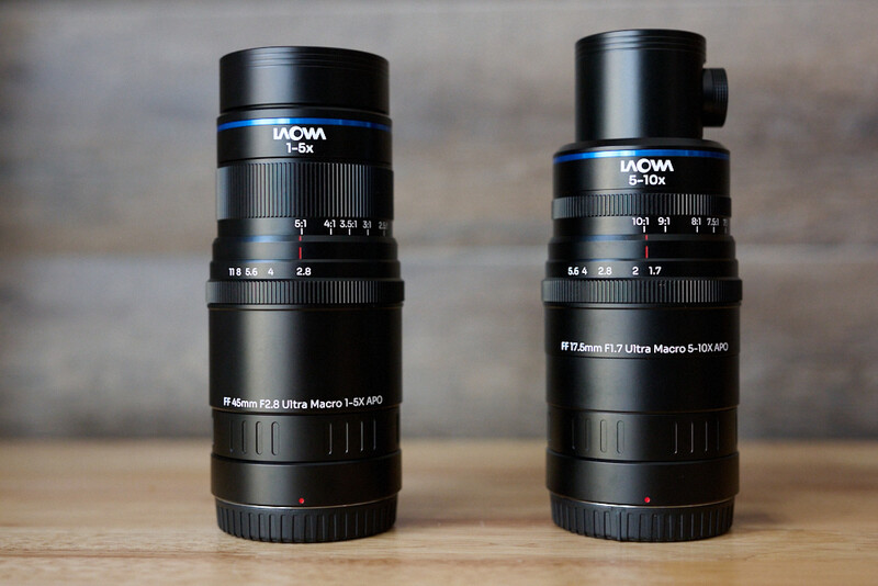 Two Laowa macro lenses side by side on wooden surface