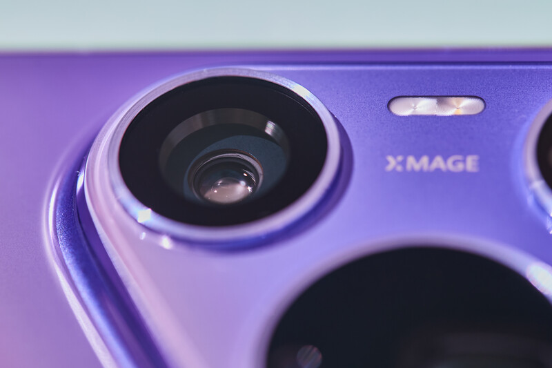 Close-up of a purple smartphone camera module showing primary lens with metallic ring