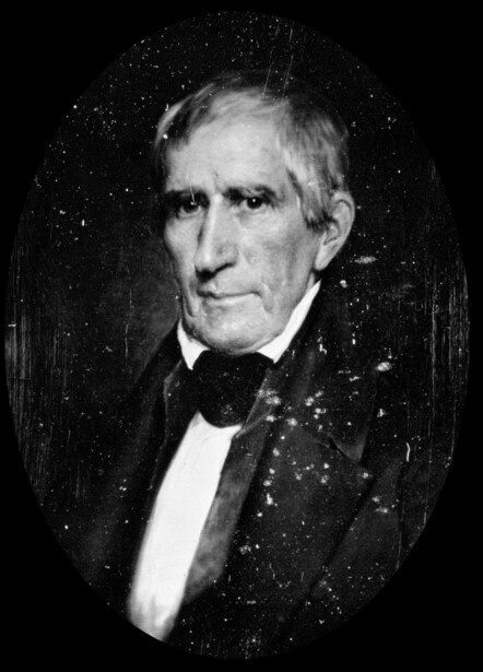 Historical portrait photograph of an older man in formal 19th-century attire with bow tie