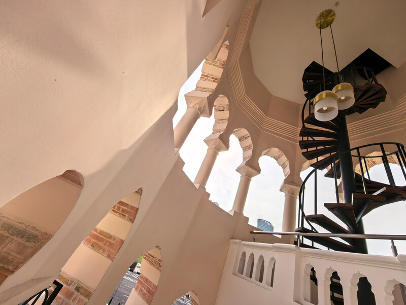 Upward architectural photograph of a modernist building interior with dramatic skylight and geometric forms