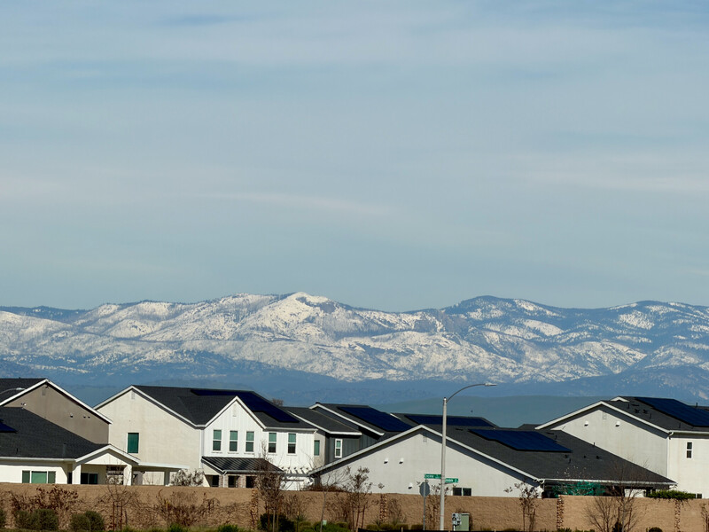 Suburban houses with snow-capped mountain range in background