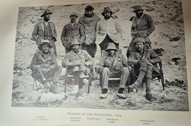 Nine men in period clothing arranged in two rows for a formal expedition group portrait, 1924