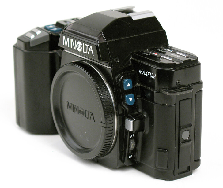 Minolta Maxxum film SLR camera body shown from three angles against white background