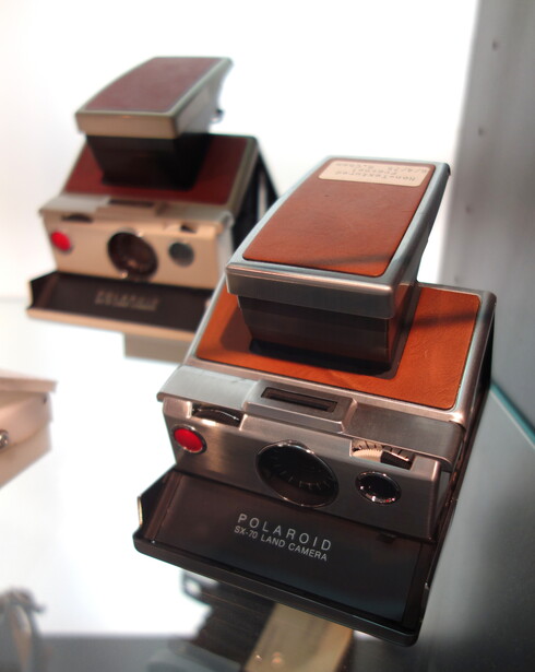 Three vintage Polaroid instant cameras stacked and displayed against a white background
