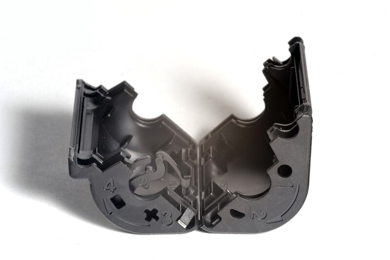 Disassembled black plastic camera or electronic device housing with interlocking components