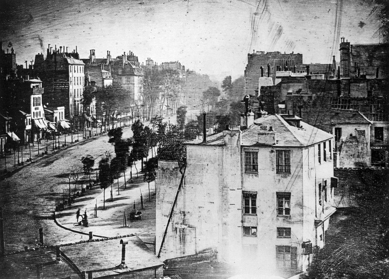 Historical black and white street scene showing urban architecture and perspective down a wide boulevard