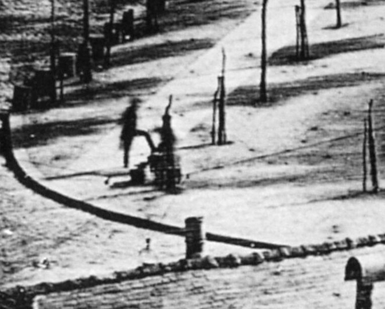 Black and white photograph of children playing in an outdoor area with ropes and posts