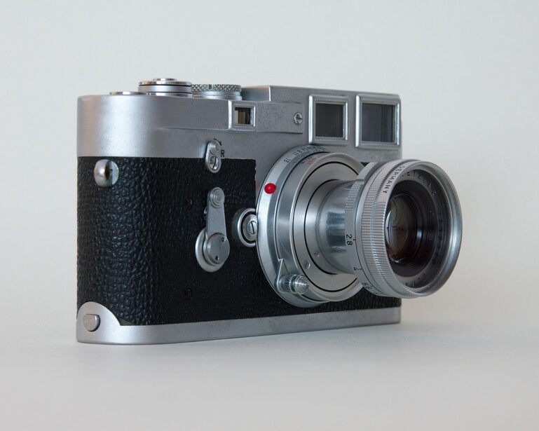 Vintage rangefinder camera with chrome top plate and black leather body