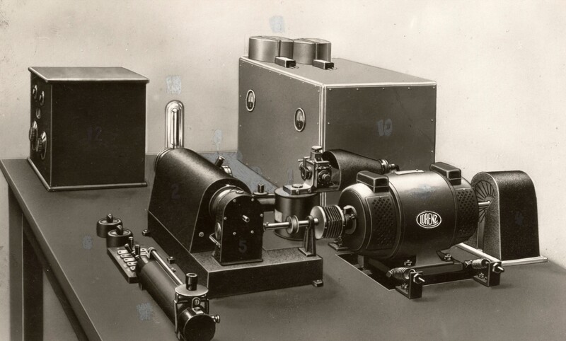 Vintage darkroom enlarger and printing equipment arranged on a table