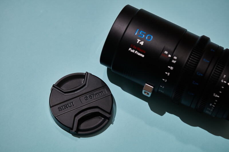 Sirui 50mm T1.4 full-frame cine lens with front cap on light blue background