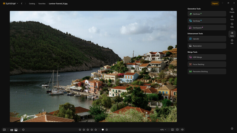 Coastal village with colorful houses on hillside overlooking harbor with sailboat
