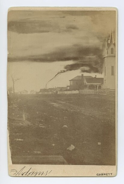 Sepia-toned vintage photograph of a rural church with stormy sky